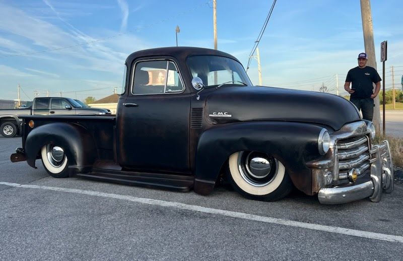 Black lowered GMC pickup with whitewall tires