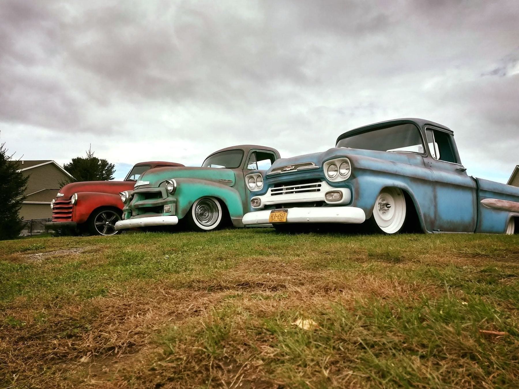 Three customized classic pickups parked together
